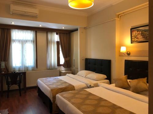 a hotel room with two beds and a table at Taksim House Suites in Istanbul