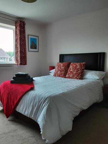 a bedroom with a large white bed with red pillows at Snoozefrome in Frome