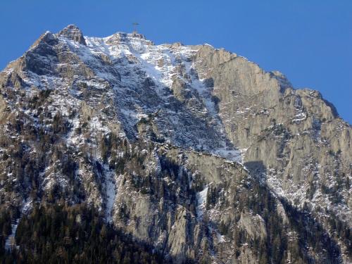 a snow covered mountain with a cross on it at Casa cu Flori in Buşteni