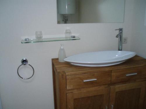 a bathroom with a white sink and a mirror at Stadtferienwohnung in Teterow
