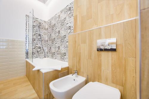un baño con inodoro y lavabo en Spacious RiverViews Apartment near Piata Unirii, en Oradea