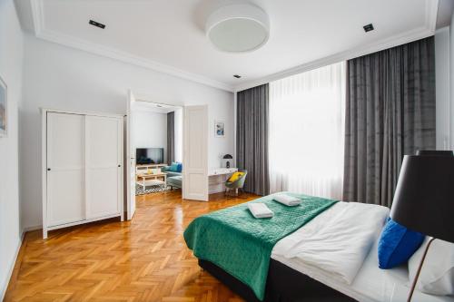 Un dormitorio con una cama con una manta verde encima. en Spacious RiverViews Apartment near Piata Unirii, en Oradea