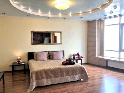 VIP апартаменти з видом на озеро في كييف: غرفة نوم مع سرير كبير مع وسائد أرجوانية