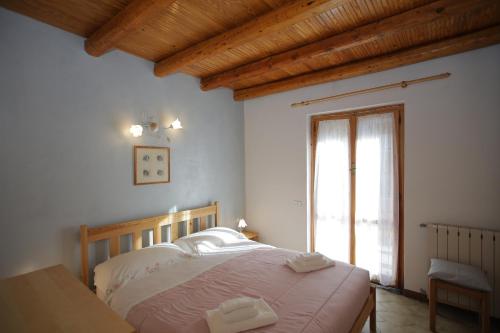 a bedroom with a large bed and a window at Green Riviera Case Vacanza in Borzonasca