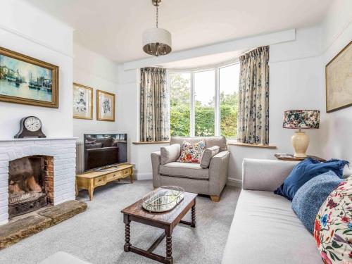 a living room with a couch and a fireplace at Pretty Three Bedroomed home near the Beach - Pass the Keys in Chichester