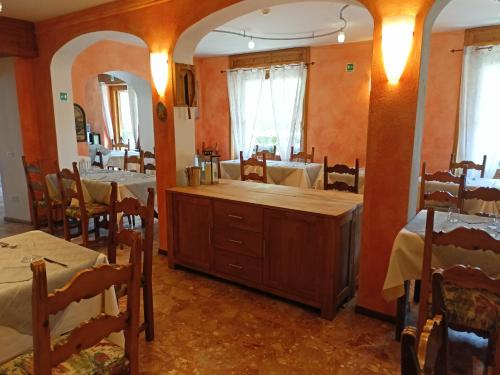 una sala da pranzo con tavoli, sedie e bancone di Hotel Daniela a Bormio