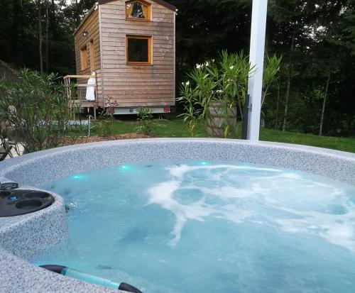 a hot tub in a backyard with a dog house at Giteovosges in La Croix-aux-Mines