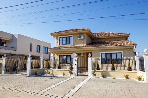 a house with a fence in front of it at Pensiunea Carpe Diem Spa in Dumbrăviţa