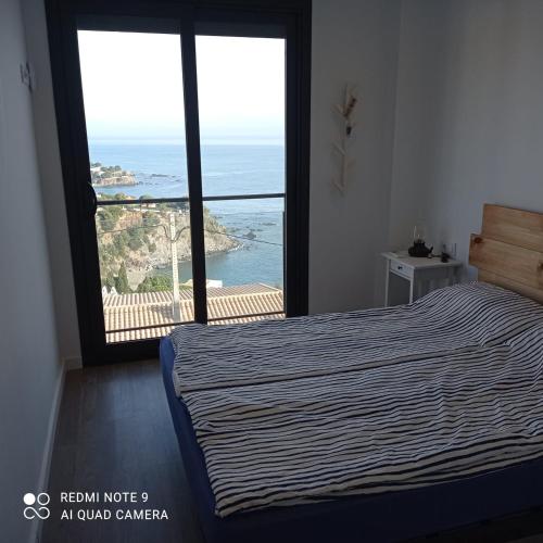 a bedroom with a bed and a view of the ocean at Llançà Apartament Platja Cau del Llop in Llança