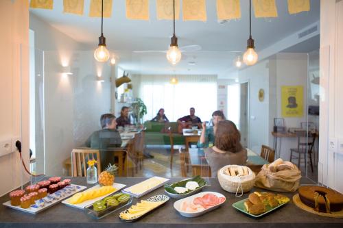 a group of people sitting at a table with food at THE HOLY COW - Hostel & Suites in Ponta Delgada