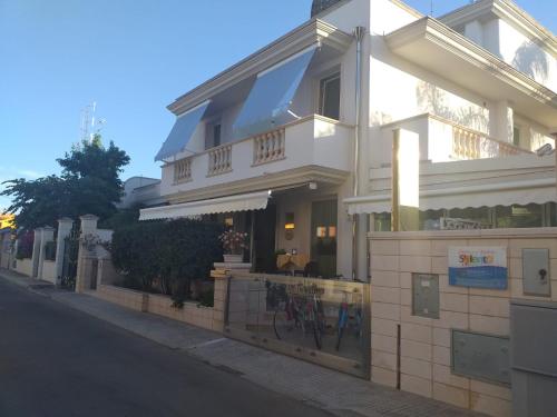 a white building on the side of a street at Falli Exclusive Rooms and Breakfast in Porto Cesareo