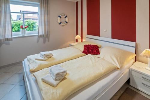 een slaapkamer met 2 bedden en handdoeken bij Noerder-Refugium in Norden