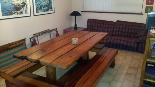 a wooden table in a living room with a couch at Lagoon Edge in Hermanus