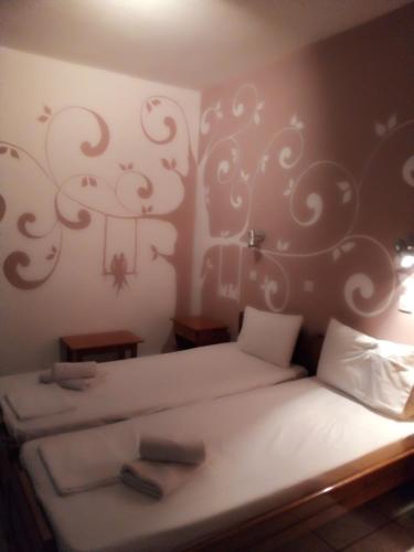 1 dormitorio con 2 camas y una pared con un mural de árboles en Alexandra rooms, en Skala Potamias