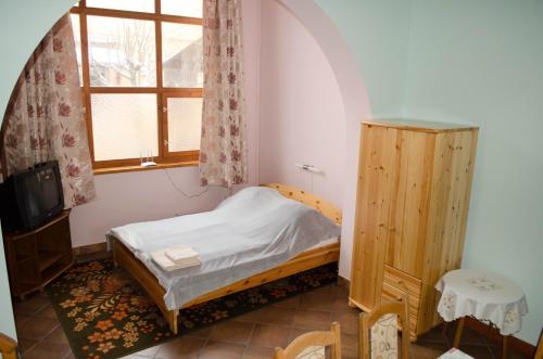 a small bedroom with a small bed and a window at Gesztenye Apartman in Makó