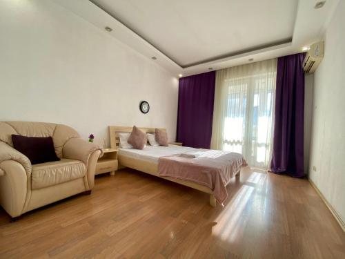 a bedroom with a bed and a couch at Central Apartments in Odesa
