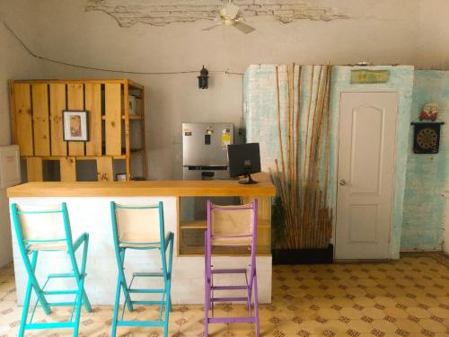 um bar com duas cadeiras roxas e uma secretária com um computador em Hostal Españolete em Santa Marta