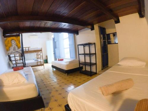 a room with a bed, a chair, and a window at Hostal Españolete in Santa Marta