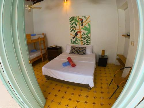 a bedroom with a bed with a yellow floor at Hostal Españolete in Santa Marta