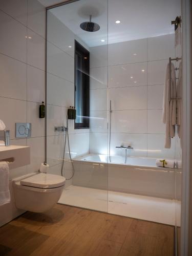 a white bathroom with a tub and a toilet at Hotel Palacio La Marquesa 4 Estrellas SUP in Teruel