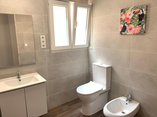 uma casa de banho com um WC, um lavatório e uma janela em Casa Elena de Novelda em Novelda