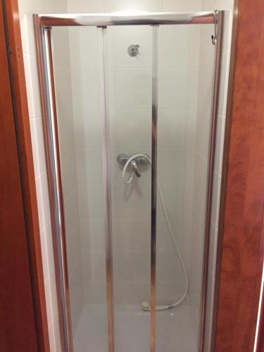 a shower with a glass door with a shower at Pensjonat Anker pokoje in Ustronie Morskie