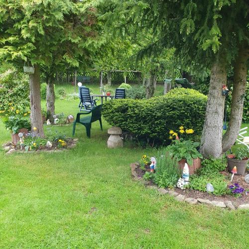 a garden with two trees and a bench and flowers at Schau ins Land in Elbingerode