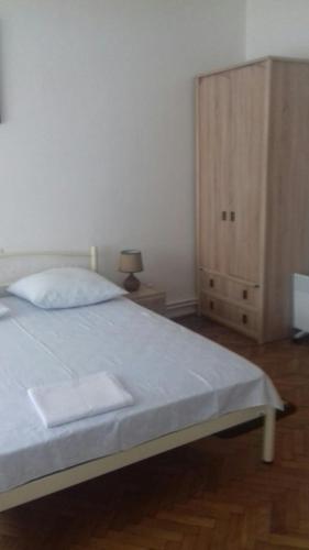 a bedroom with a white bed and a cabinet at Gelena Гостьовий двір in Uzhhorod