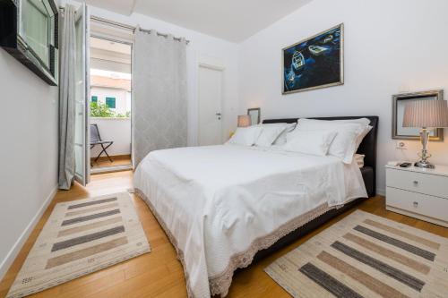a bedroom with a large white bed and a window at Luxury Apartment Set in Split