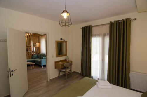 a bedroom with a bed and a desk and a window at L & A - GUEST HOUSE in Skala Potamias