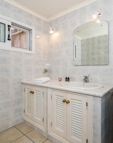 a bathroom with a sink and a mirror at Villa Nitsa in Vathi