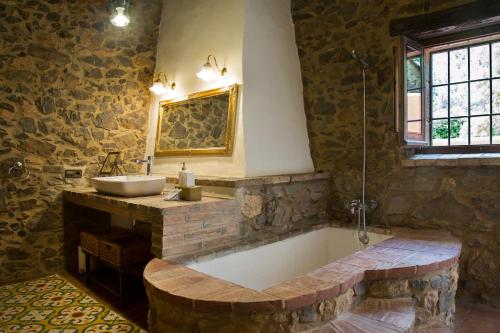 a bathroom with a bath tub and a sink at Mas Tomas in Vall-Llobrega