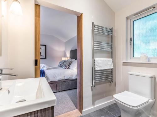 a bathroom with a sink and a toilet and a bed at Pass the Keys Delightful 2Bed Lodge in Downland Village in Chichester