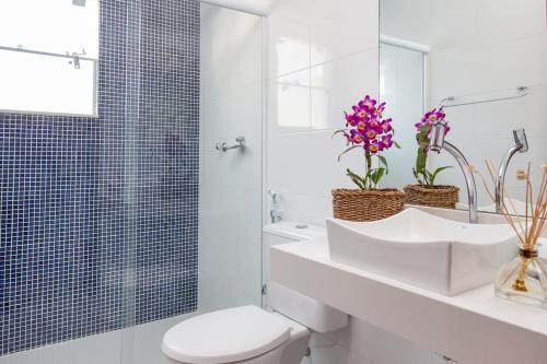 bagno bianco con servizi igienici e doccia di Luar de Geribá a Búzios