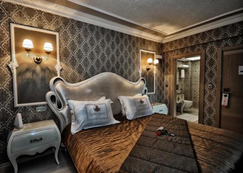 a bedroom with a large bed with a large headboard at Grand Atakum Hotel in Samsun