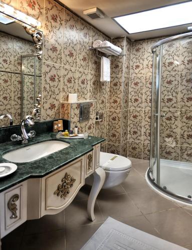 a bathroom with a sink and a toilet and a shower at Grand Atakum Hotel in Samsun