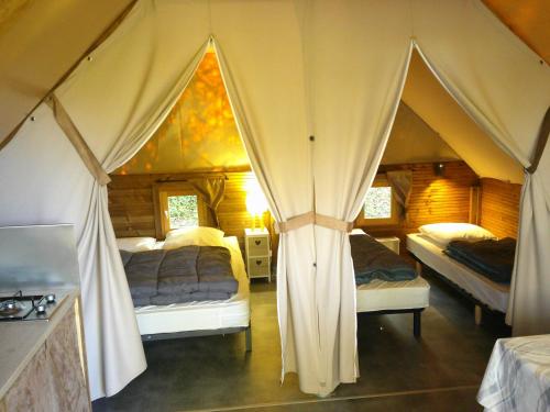 En eller flere senge i et værelse på Camping Smile & Braudieres