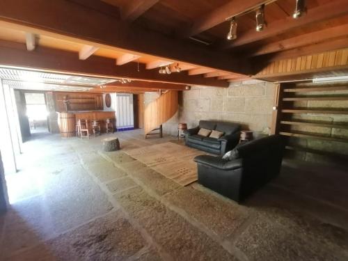 an empty living room with a couch and a piano at Quinta do Carvalho - Nature Guest Houses in Guimarães