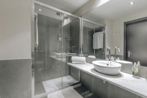 a large bathroom with a sink and a shower at Hotel Continental in Cremona