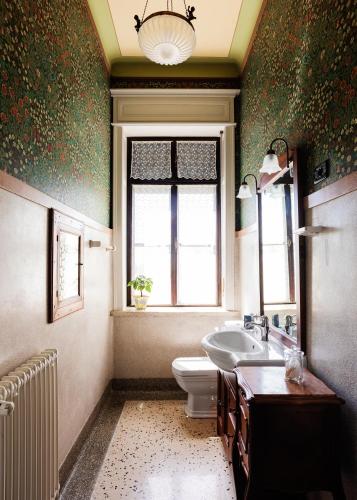a bathroom with a toilet and a sink and a window at Villa Maraldo 1927 in Orgnese