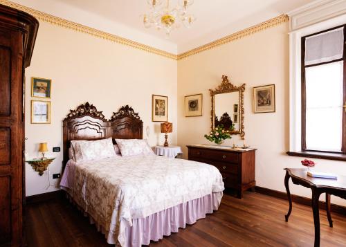 a bedroom with a large bed and a mirror at Villa Maraldo 1927 in Orgnese