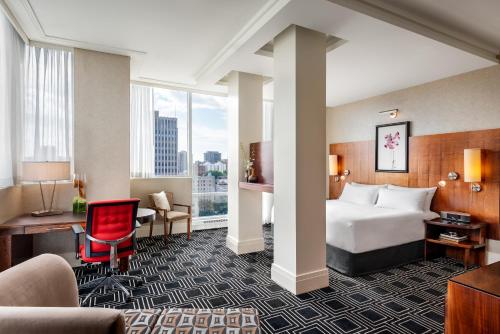 a hotel room with a bed and a desk at Sofitel Montreal Golden Mile in Montréal