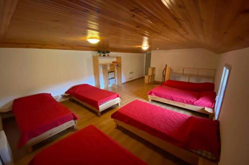 two beds in a room with red sheets at Gîte du Clos Basté in Moncaup