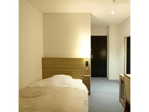 1 dormitorio con 1 cama y pared con TV en Pure Hotel - Vacation STAY 44177v en Yabu
