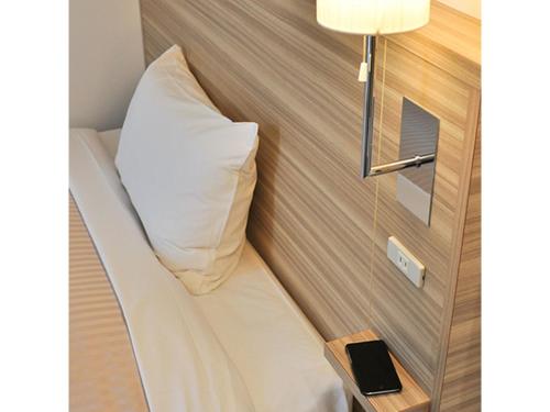 Bett in einem kleinen Zimmer mit Kissen darauf in der Unterkunft Pure Hotel - Vacation STAY 44185v in Yabu