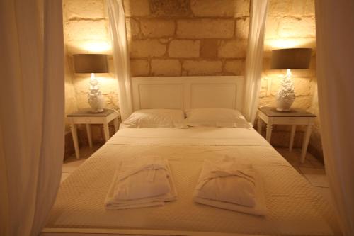 1 dormitorio con 1 cama con 2 toallas en La Suite di Martina, en Lecce