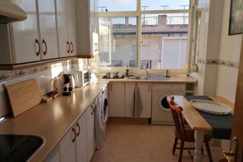 a kitchen with a sink and a dishwasher and a table at Casa Gisbert Centro histórico Parking Free in Cartagena