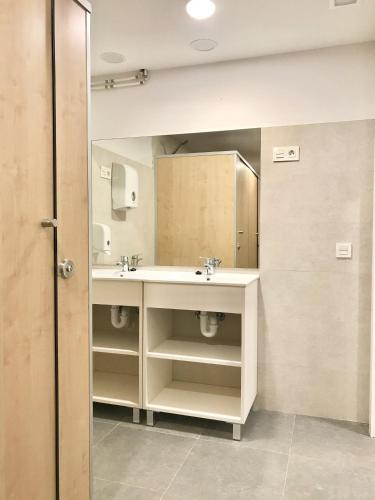 a bathroom with two sinks and a mirror at Quartier Leon Hostel Jabalquinto in León