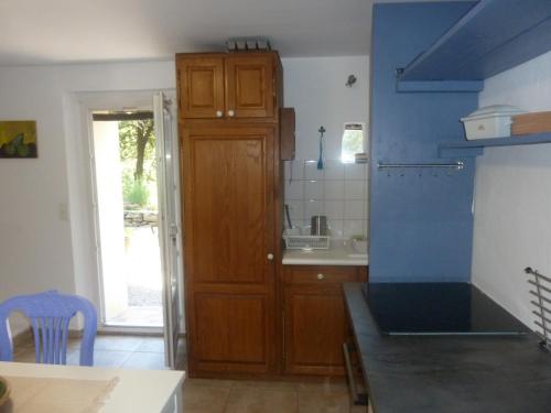 Villa Les Oliviers في دراجوينا: مطبخ مع خزانة خشبية ومغسلة