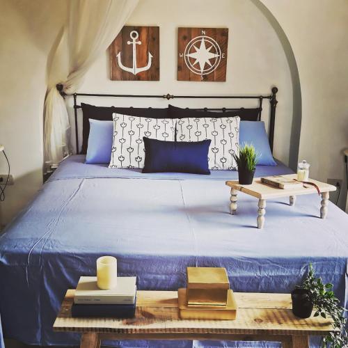 a bedroom with a blue bed with a wooden table at Dammuso Sant'Anna in Pantelleria